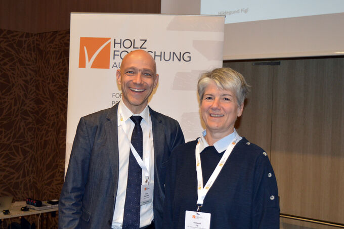 Martin Weigl-Kuska and Hildegund Figl in front of the Holzforschung Austria roll-up banner.