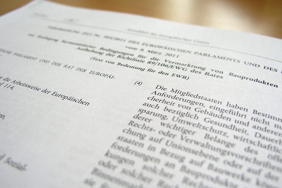 Ein Informationsblatt zur CE-Kennzeichung liegt auf einem Holztisch.